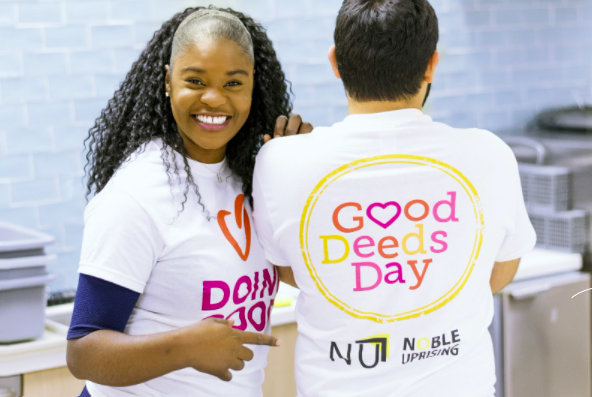 Audrey pointing to a shirt that says "Good Deeds Day"
