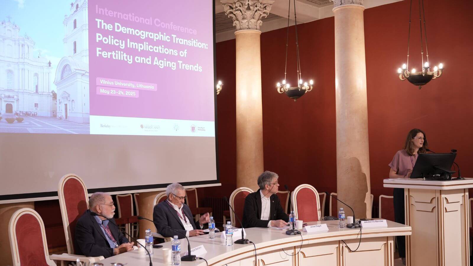 image of people sitting at rounded conference table with large screen behind them