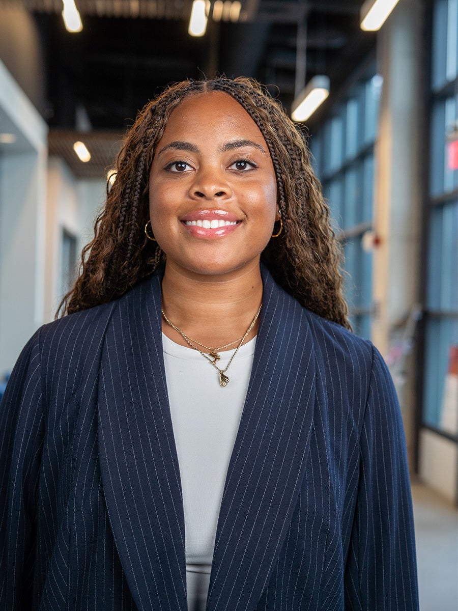 Lindsey Layton poses and smiles with braids and a blue jacket