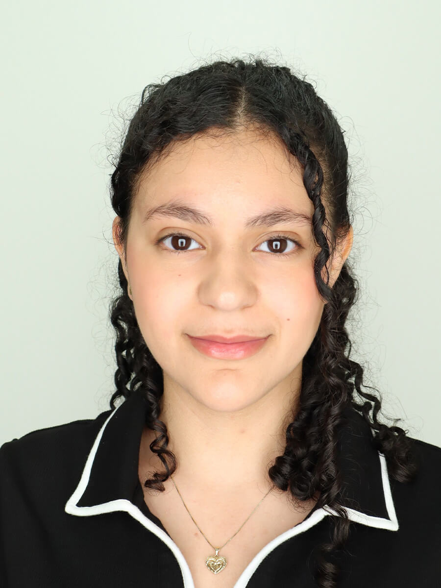 Headshot of a woman in a black shirt with white collar outlines.