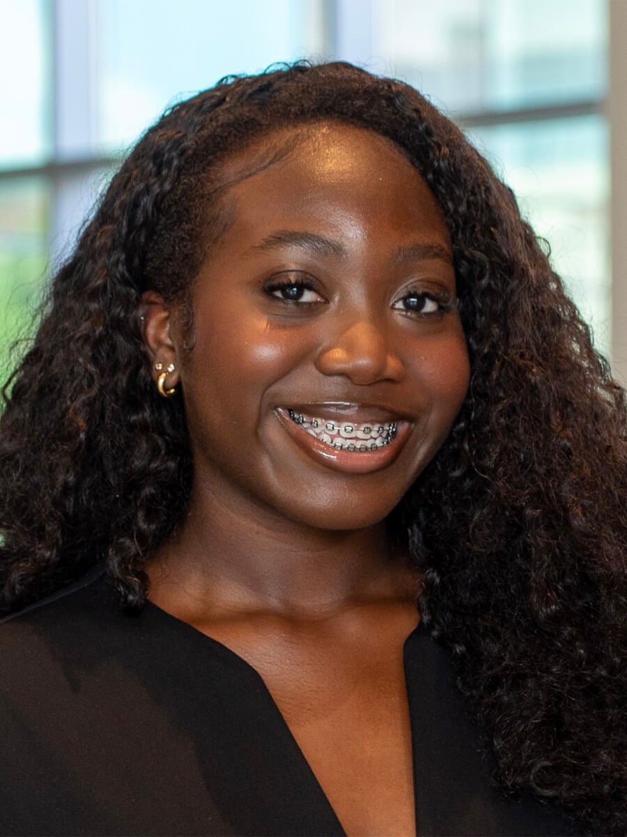 Headshot of a woman smiling in a black blouse. 