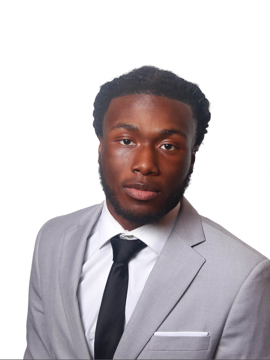 Headshot of student wearing a gray suit and black tie 