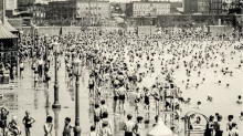Black and white image of a bunch of people in bathing suits at a community pool 