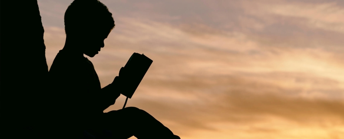 Boy reading, photo by Aaron Burden