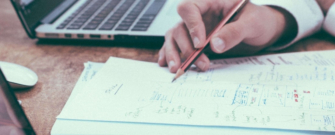 taking notes with paper and laptop