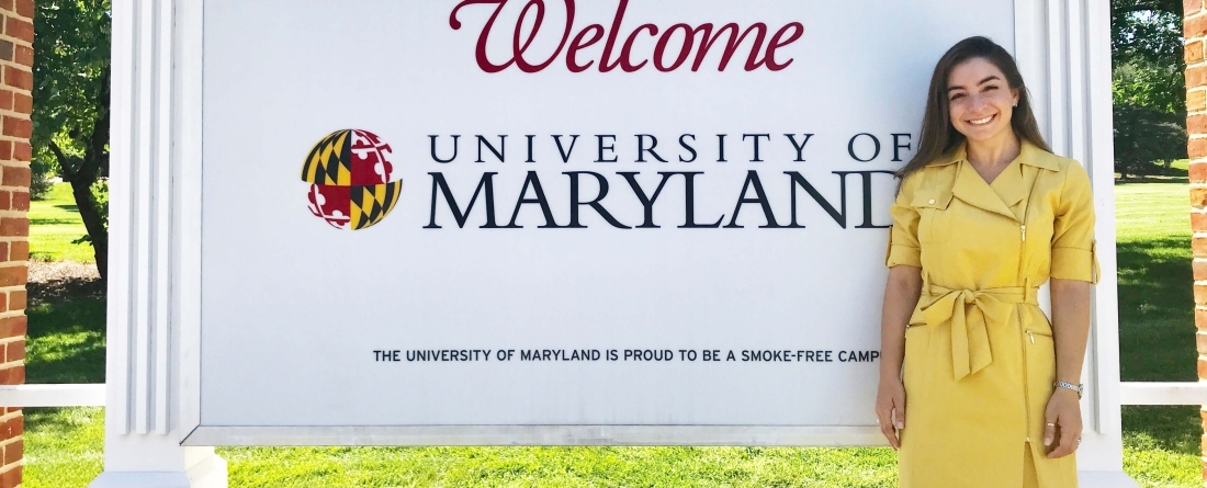Ariana Scurti MPP'19 in front of Welcome to UMD sign