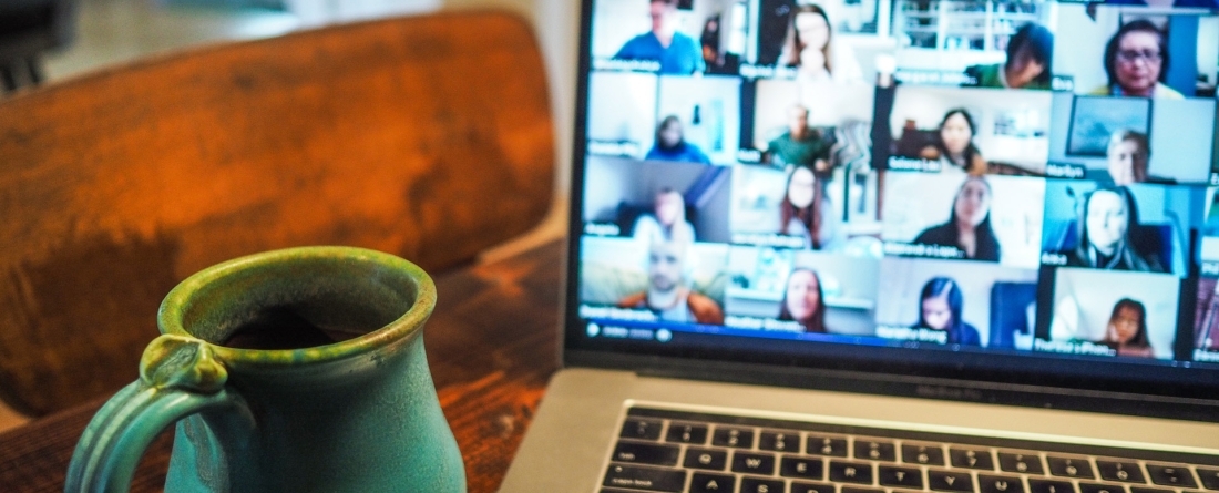 picture of a zoom call at home, a coffee mug next to the laptop