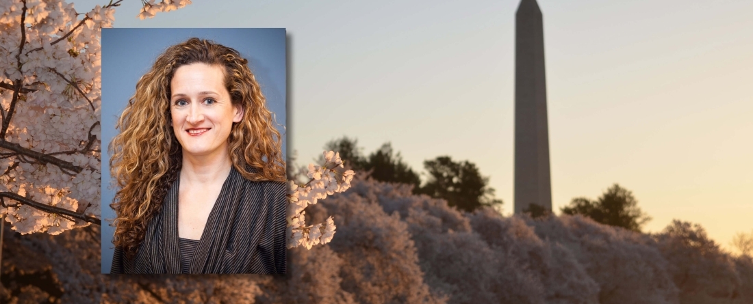 Patricia Bory headshot, background is DC monument with cherry blossoms in bloom
