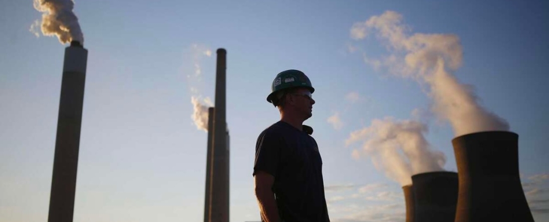 picture of a worker in front of a coal plant