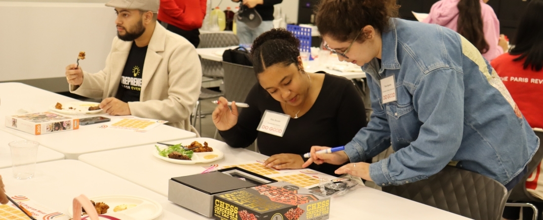 Students sitting around table playing a board game