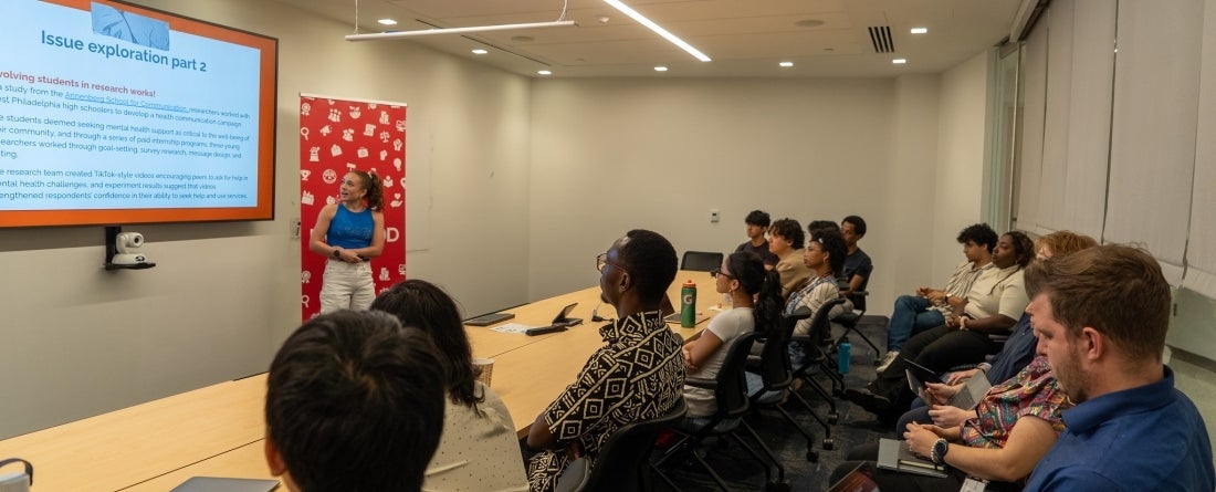 A female student is presenting to a classroom of her peers. 