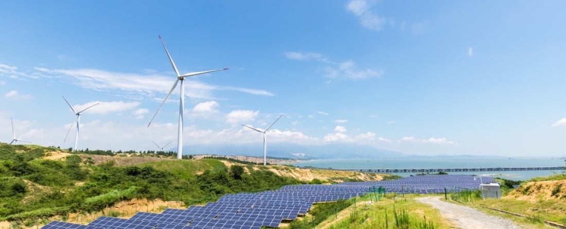 picture of solar panel farm and wind turbines
