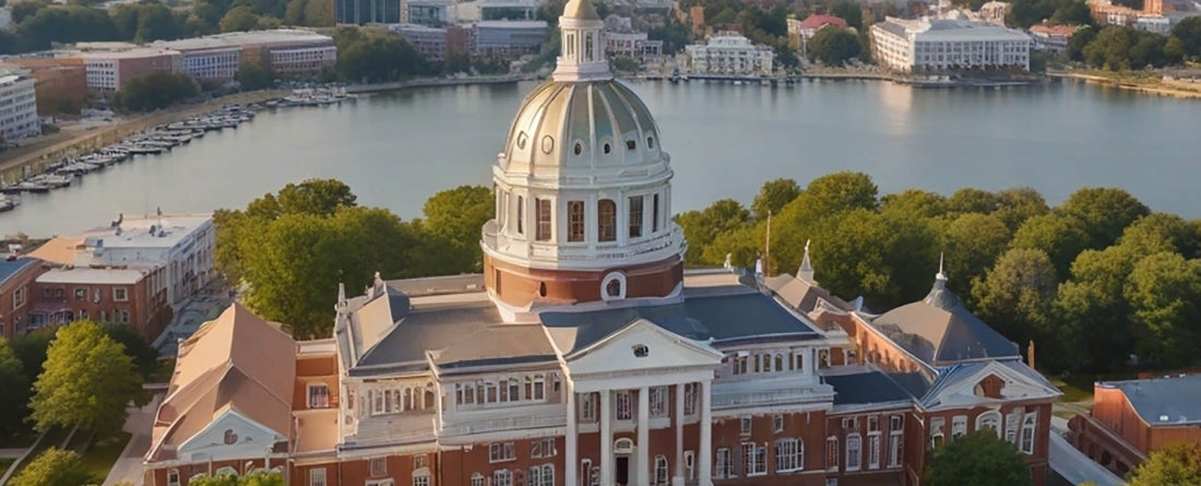 aerial image of Annapolis State House on a sunny day with Chesapeake Bay visible behind it.