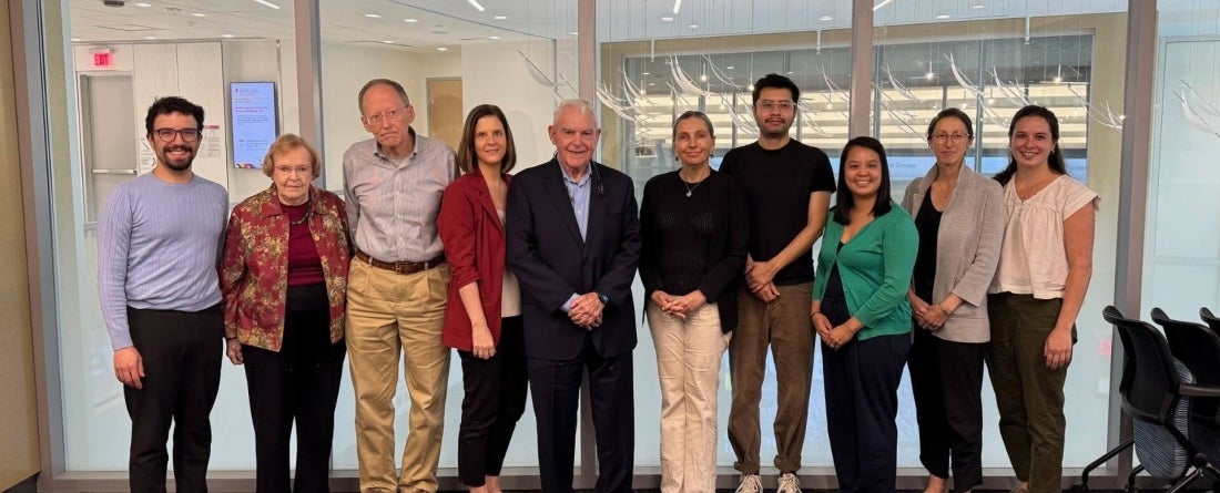 group of people standing in front of glass wall