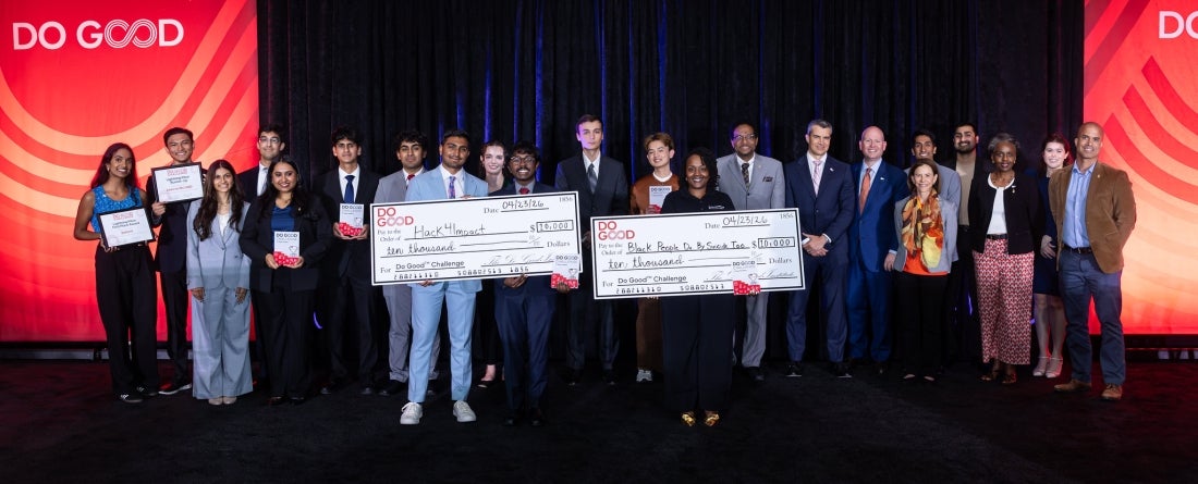 All the finalists standing on stage at the Do Good Challenge Finals, hoisting their awards amongst UMD President Darryll Pines & SPP Dean